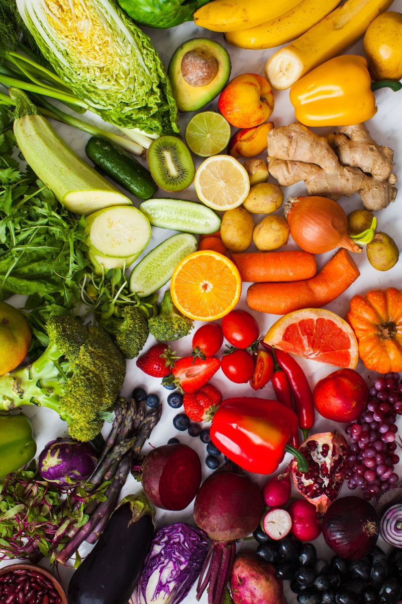 A vibrant assortment of fresh fruits and vegetables including broccoli, oranges, carrots, and berries, symbolising a healthy and balanced diet for improved nutrition